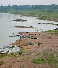 People fish along exposed banks, due to low water levels on Tri An Lake in Vinh Cuu, Dong Nai Province, Vietnam, on May 30. Major hydropower reservoirs in Vietnam are facing severe water shortages for the rest of the dry season due to El Niño, heat waves and drought.
Mandatory Credit:	Linh Pham/Bloomberg/Getty Images
