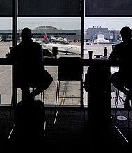 Passengers are seen in silhouette at a Delta Sky Club as an airplane parks at a gate in front of them at Hartsfield-Jackson Atlanta International Airport ahead of the Fourth of July holiday in Atlanta, Georgia, U.S., July 1, 2022.
Mandatory Credit:	Elijah Nouvelage/Reuters/FILE