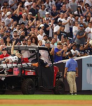 Pete Stendel waves to the crowd as he is carted off the field after getting hit by an errant throw in the fifth inning during the game between the New York Yankees and the Baltimore Orioles.
Mandatory Credit:	Mike Stobe/Getty Images