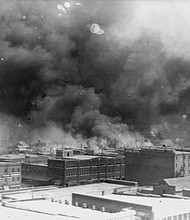 In this 1921 image provided by the Library of Congress, smoke billows over Tulsa, Okla. An Oklahoma judge has thrown out a lawsuit seeking reparations for the 1921 Tulsa Race Massacre, dashing an effort to obtain some measure of legal justice by survivors of the deadly racist rampage.