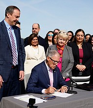 Washington Gov. Jay Inslee prepares to sign House Bill 1340, which protects health care providers in Washington from disciplinary action for providing legal abortion and gender-affirming care in Washington, April 27, at the University of Washington's Hans Rosling Center for Population Health in Seattle.
Mandatory Credit:	Lindsey Wasson/AP