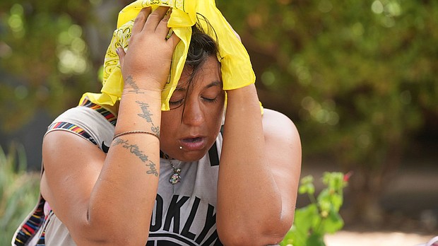 Kristin Peterson tries to cool off with a cold bandana in Austin, Texas, amid a stifling heat wave.
Mandatory Credit:	Jay Janner/Austin American-Statesman via AP