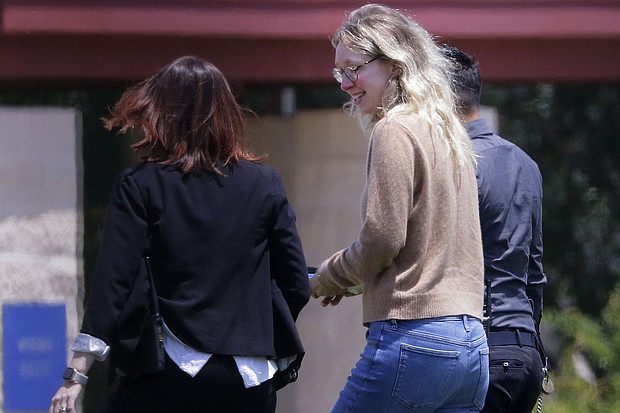 Disgraced Theranos CEO Elizabeth Holmes, center, is escorted by prison officials into a federal women's prison camp on May 30, 2023, in Bryan, Texas.
Mandatory Credit:	Michael Wyke/AP