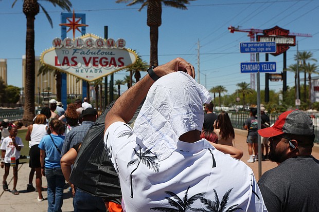 A man shields himself from the sun while waiting to take a photo in Las Vegas on July 14.
Mandatory Credit:	Ronda Churchill/AFP/Getty Images