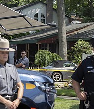 New York State police officers stand guard as law enforcement searches the home of Rex Heuermann, Saturday, July 15, in Massapequa Park, New York.
Mandatory Credit:	Jeenah Moon/AP