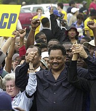 Jesse Jackson, center, founder of Rainbow PUSH, and NAACP president Kweisi Mfume, right, join hands as they arrive at Greenville County Square for a rally in a Dignity Day March on May 17, 2003, in Greenville, S.C.