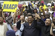 Jesse Jackson, center, founder of Rainbow PUSH, and NAACP president Kweisi Mfume, right, join hands as they arrive at Greenville County Square for a rally in a Dignity Day March on May 17, 2003, in Greenville, S.C.