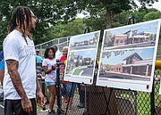 Johnny Noble reviews renderings of the new school after the ceremony.