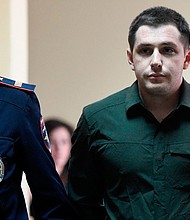 Police officers escort US ex-marine Trevor Reed, charged with attacking police, into a courtroom prior to a hearing in Moscow on March 11, 2020.
Mandatory Credit:	Alexander Nemenov/AFP/Getty Images