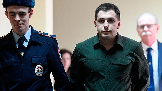 Police officers escort US ex-marine Trevor Reed, charged with attacking police, into a courtroom prior to a hearing in Moscow on March 11, 2020.
Mandatory Credit:	Alexander Nemenov/AFP/Getty Images