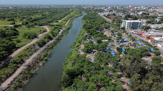 A makeshift camp, where asylum seekers wait as they attempt to cross into the US, lines the Rio Grande river border between Brownsville, Texas and Matamoros, in Matamoros, Mexico, on June 20.
Mandatory Credit:	Daniel Becerril/Reuters