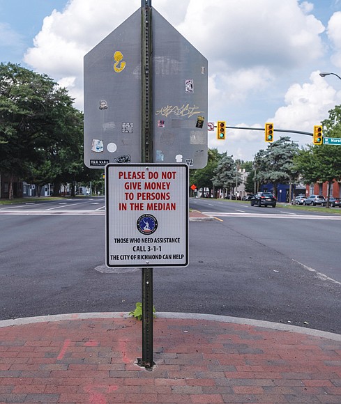 New signs at Belvidere and Marshall streets are among several throughout the city that ask drivers to stop giving money to panhandlers.