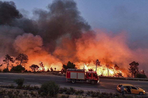 A fire truck moves along a road as a forest fire rages near the town of Melloula in northwestern Tunisia on July 24.
Mandatory Credit:	Fethi Belaid/AFP/Getty Images