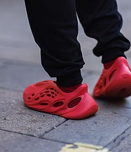A fashion week guest seen wearing red Adidas Yeezy shoes during London Fashion Week in September 2022.
Mandatory Credit:	Jeremy Moeller/Getty Images