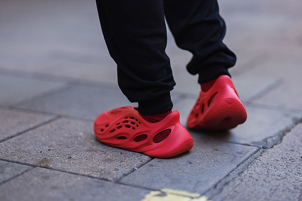 A fashion week guest seen wearing red Adidas Yeezy shoes during London Fashion Week in September 2022.
Mandatory Credit:	Jeremy Moeller/Getty Images