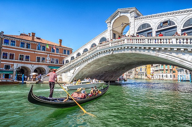 A gondola packed with tourists goes under the Rialto Bridge on the Grand Canal in Venice.
Mandatory Credit:	Eloi_Omella/iStock Unreleased/Getty Images
