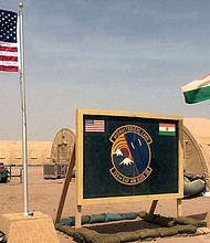 In this April 2018 file photo, US and Niger flags are raised side by side at the base camp for air forces and other personnel supporting the construction of Niger Air Base 201 in Agadez, Niger.
Mandatory Credit:	Carley Petesch/AP/File