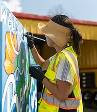 Houston artist, Caroline Truong, paints a Traffic Signal Control Cabinet (TSCC) in Bonita Gardens.