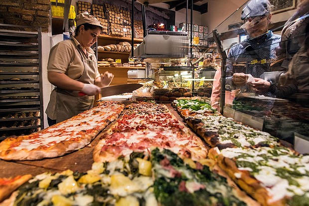 Different varieties of pizza served al taglio in a bakery of Rome's Trastevere neighborhood.
Mandatory Credit:	Stefano Politi Markovina/Alamy Stock Photo