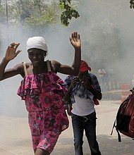 Haitians flee tear gas fired by officers clearing a camp of people at the US embassy seeking to escape the violence of armed gangs on July 25.
Mandatory Credit:	Ralph Tedy Erol/Reuters