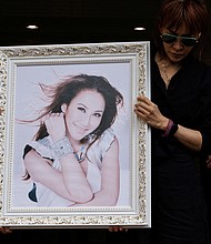 Relatives carry a portrait of singer and songwriter CoCo Lee at a crematorium after the funeral in Hong Kong.
Mandatory Credit:	Tyrone Siu/Reuters