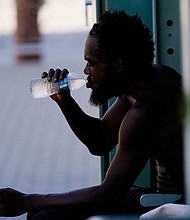 A person drinks a bottle of water in the shade as temperatures are expected to hit 119-degrees Thursday, July 20, in Phoenix.
Mandatory Credit:	Ross D. Franklin/AP