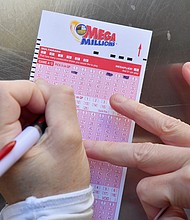 A woman fills out a Mega Millions lottery ticket on October 19, 2018, in New York City.
Mandatory Credit:	Angela Weiss/AFP/Getty Images
