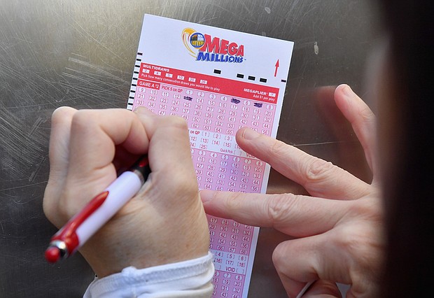 A woman fills out a Mega Millions lottery ticket on October 19, 2018, in New York City.
Mandatory Credit:	Angela Weiss/AFP/Getty Images