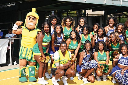 Cheerleaders from both teams pause for a photo during the game.