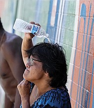 People who are homeless try to cool down with chilled water outside the Justa Center, a day center for homeless people 55 years and older, on July 14 in downtown Phoenix. A historic heat wave turned the Southwest into a blast furnace throughout July. Other parts of the country also felt the heat.