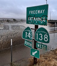 A vehicle engulfed in water drives through a flooded freeway entrance in Palmdale, California.
Mandatory Credit:	Richard Vogel/AP