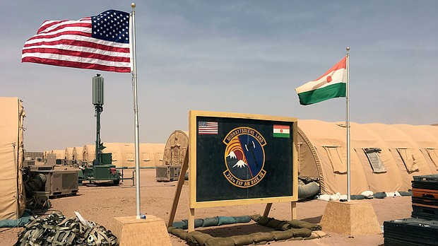 In this April 2018 photo, US and Niger flags are raised side by side at the base camp for air forces and other personnel supporting the construction of Niger Air Base 201 in Agadez, Niger.
Mandatory Credit:	Carley Petesch/AP