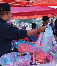 Wayman Hollis and his sons, Wayman Hollis Jr. and Landon Hollis, were in charge of organizing backpacks for the giveaway.
