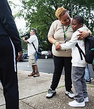 Principal Angela Wright of Fairfield Court Elementary School advocated for the extra days and even offered to pick up students whose parents couldn’t walk them to school. Above, Principal Wright greets a returning student on July 24, the opening day of the extended 200-day school year.