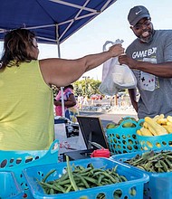 Second Baptist Church’s pastor, the Rev. Ralph Hodge buys fresh produce at the Broad Rock Farmers’ Market that was part of the event. Rounding out the attractions were a bounce house, video game truck, a free CPR class and lunch.