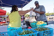 Second Baptist Church’s pastor, the Rev. Ralph Hodge buys fresh produce at the Broad Rock Farmers’ Market that was part of the event. Rounding out the attractions were a bounce house, video game truck, a free CPR class and lunch.