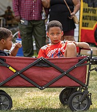 Brothers Canon, right, and Chase Wright enjoy a wagon ride steered by their father, Derek Wright, during the 20th Happily Natural Festival and Urban Farm Expo last Saturday in Richmond.