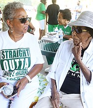 Katrina Hicks, a member of the Maggie L. Walker High School Class of 1968, left, catches up with her retired business teacher, Marjorie Saunders, 103, during the annual Maggie L. Walker High School Alumni Mass Classes Mighty Green “Fellowship Day” reunion Aug. 20 at Dorey Park in Henrico County. Class members celebrated their former teacher, who also taught government and typing courses.