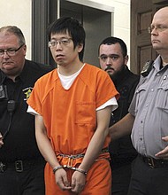 Tailei Qi, the graduate student suspected in the fatal shooting of a University of North Carolina at Chapel Hill faculty member, center, makes his first appearance at the Orange County Courthouse in Hillsborough, N.C., on Tuesday.