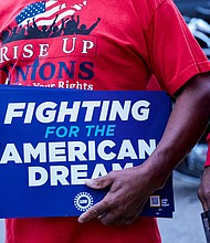 A United Auto Workers union member holds a sign outside Stellantis Sterling Heights Assembly Plant, to mark the beginning of contract negotiations in Sterling Heights, Michigan on July 12.
Mandatory Credit:	Rebecca Cook/Reuters