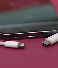 An iPhone 14 Pro with a Lightning cable (left) and a USB-C cable (right).
Mandatory Credit:	Christoph Dernbach/picture-alliance/dpa/AP