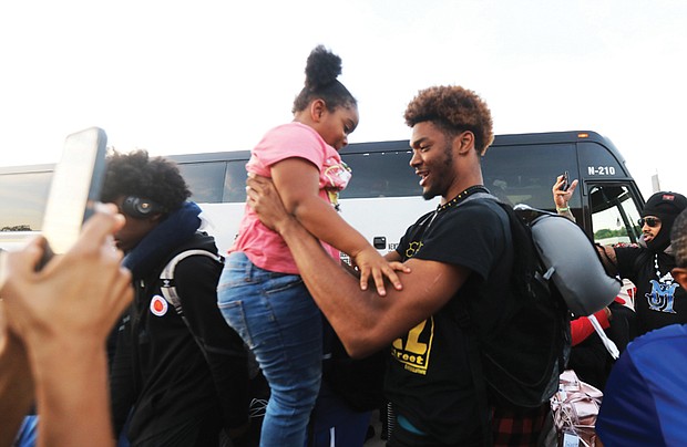 Makeyon Hill, a senior member of the John Marshall High School basketball team, greets his 5-year-old sister, Traniyah Blakey, last week after his return from a trip to Angola with the high school’s other athletes, faculty and staff.