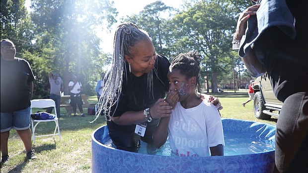 Upon This Rock World Ministries Community Impact Day took place Sept. 16 at Pine Camp Cultural Arts and Community Center on Old Brook Road in North Side. The ministry is led by Pastor Rob Wilson and Apostle Sherry Wilson. Throughout the day, encouragement and random acts of kindness were encouraged among participants. In this photo, Apostle Sheniqua Mitchell baptizes Ella Robinson.