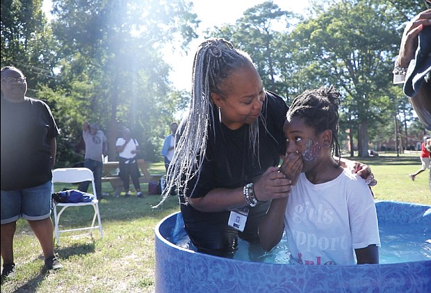 Upon This Rock World Ministries Community Impact Day took place Sept. 16 at Pine Camp Cultural Arts and Community Center on Old Brook Road in North Side. The ministry is led by Pastor Rob Wilson and Apostle Sherry Wilson. Throughout the day, encouragement and random acts of kindness were encouraged among participants. In this photo, Apostle Sheniqua Mitchell baptizes Ella Robinson.