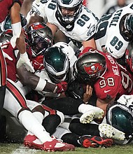 With help from his offensive line, Philadelphia Eagles quarterback Jalen Hurts scores a touchdown Monday night against the home team Tampa Bay Buccaneers.