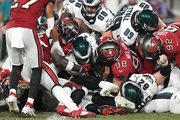 With help from his offensive line, Philadelphia Eagles quarterback Jalen Hurts scores a touchdown Monday night against the home team Tampa Bay Buccaneers.