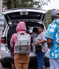 Rhonda Sneed provides food and water to people denied entry in a shelter at City Hall during Tropical Storm Ophelia on Sept. 22.