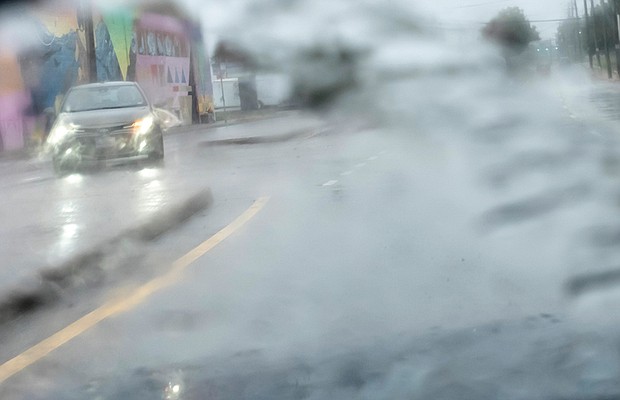 Tropical Storm Ophelia’s heavy rains, flooding and strong winds sweep through the city Sept. 23. A motorist navigates pouring rain along Meadow Street and Overbrook Road in Richmond.