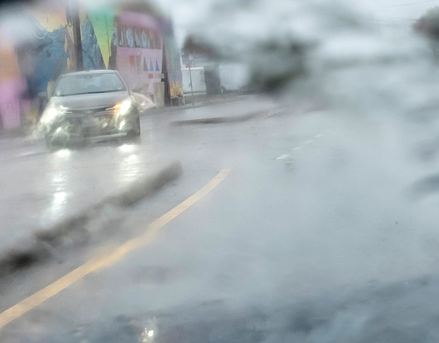Tropical Storm Ophelia’s heavy rains, flooding and strong winds sweep through the city Sept. 23. A motorist navigates pouring rain along Meadow Street and Overbrook Road in Richmond.