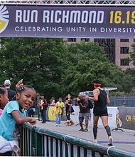 Siblings Kennedy Williams, left, and Madison Williams cheer Saturday for runners during Run Richmond 16.19, a cultural event that the Djimon Hounsou Foundation hosts in collaboration with the Black History Museum & Cultural Center of Virginia and Sports Backers.